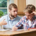 Male Home Tutor Helping Boy With Studies