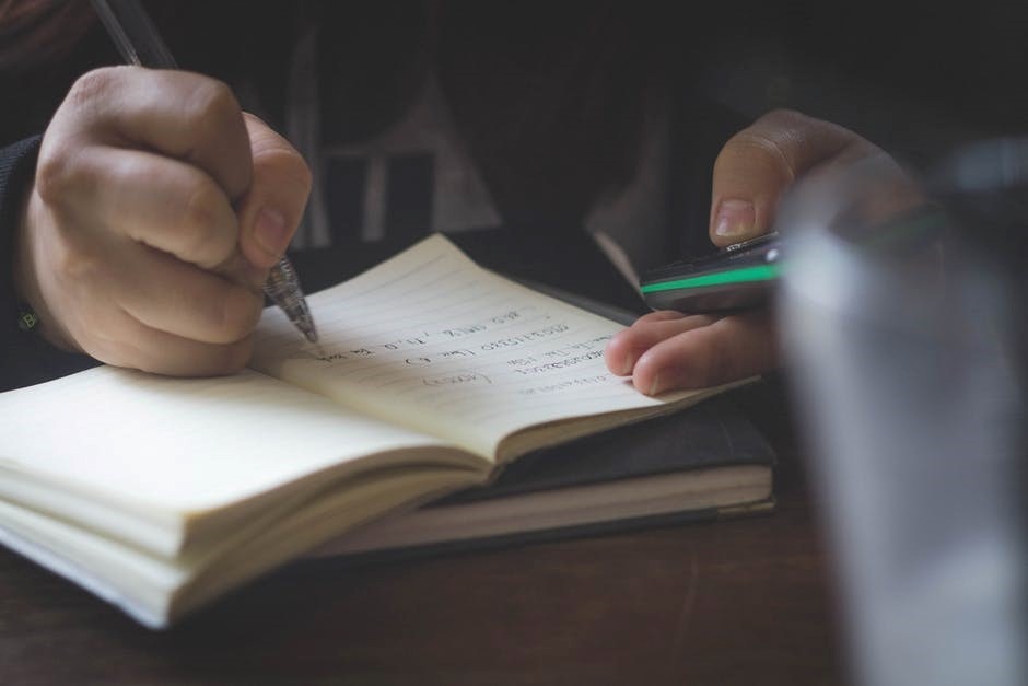 student writing in notebook while using calculator during sat math tutoring